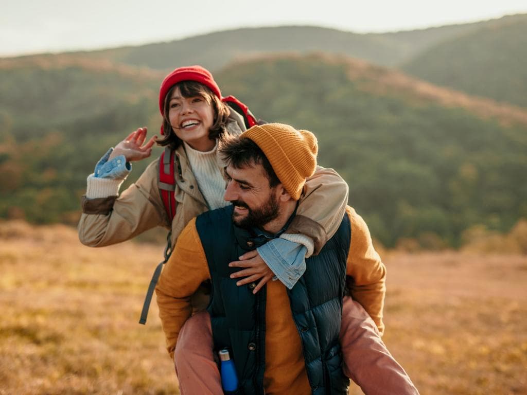 Et ungt par nyter lekne øyeblikk sammen i et pittoresk fjellandskap